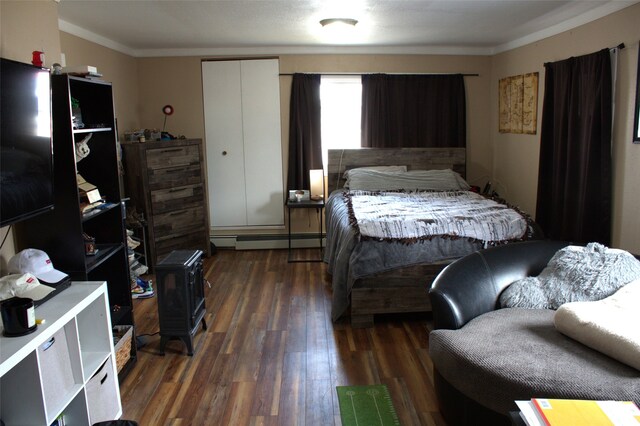 820 Lexington Ave, Butte, MT 59701 - bedroom featuring baseboard heating, crown molding, a wood stove, and dark wood-style floors