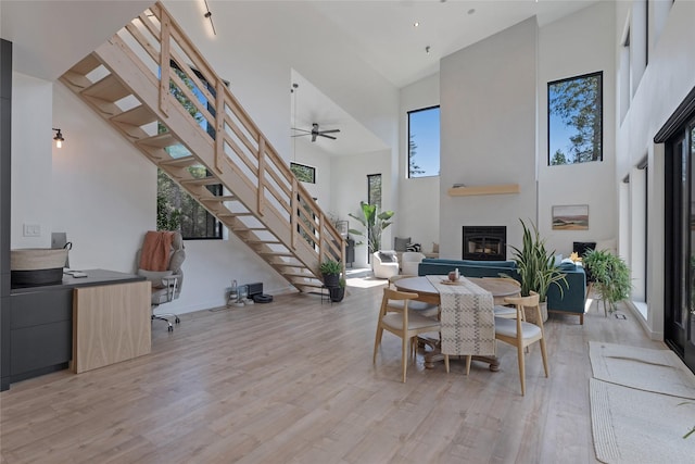 5092 US Highway 93 S, Whitefish, MT 59937 - living room featuring light wood-style floors, plenty of natural light, a glass covered fireplace, a high ceiling, and stairs