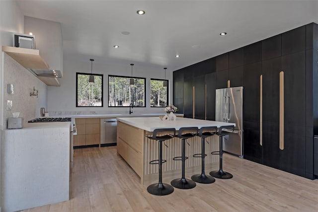 5092 US Highway 93 S, Whitefish, MT 59937 - kitchen with a kitchen breakfast bar, appliances with stainless steel finishes, light countertops, dark cabinetry, and modern cabinets