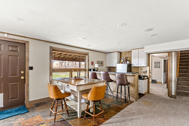 11 Wilson Butte Rd, Great Falls, MT 59405 - dining space with stairs, stone tile flooring, baseboards, a textured ceiling, and bar