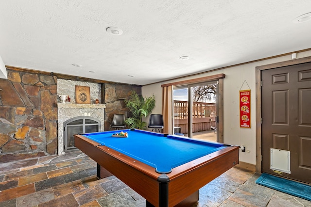 11 Wilson Butte Rd, Great Falls, MT 59405 - recreation room with a textured ceiling, stone tile flooring, a stone fireplace, and billiards table