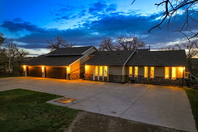 11 Wilson Butte Rd, Great Falls, MT 59405 - view of front of house featuring stone siding, concrete driveway, a lawn, and an attached garage