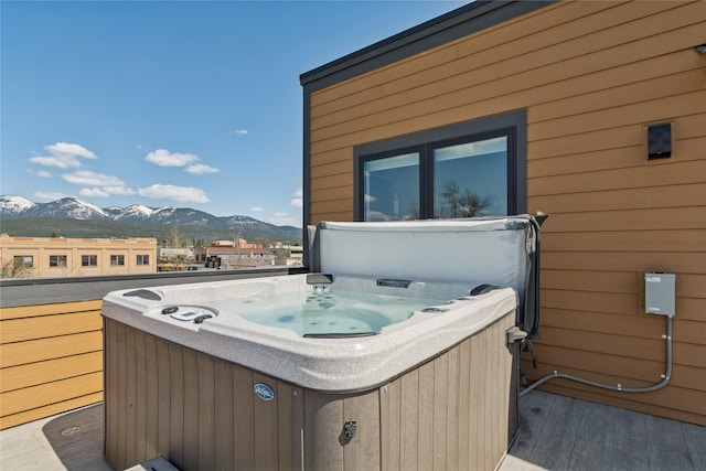 deck featuring a hot tub and a mountain view