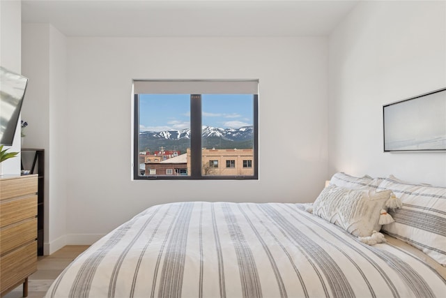 bedroom featuring baseboards and wood finished floors