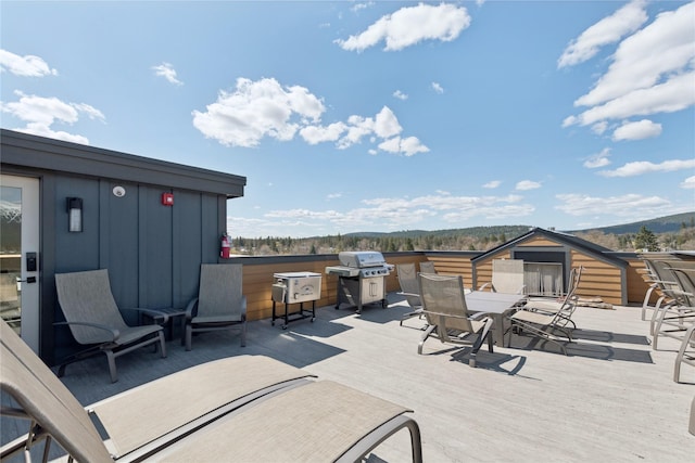 view of patio / terrace with outdoor dining area, a wooden deck, and area for grilling