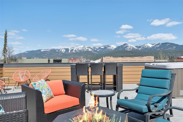 view of patio with a mountain view, a fire pit, and a balcony