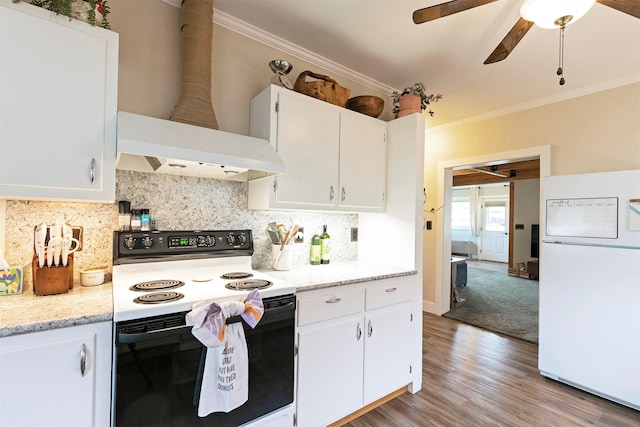 kitchen with freestanding refrigerator, ornamental molding, range with electric stovetop, ceiling fan, and wall chimney range hood