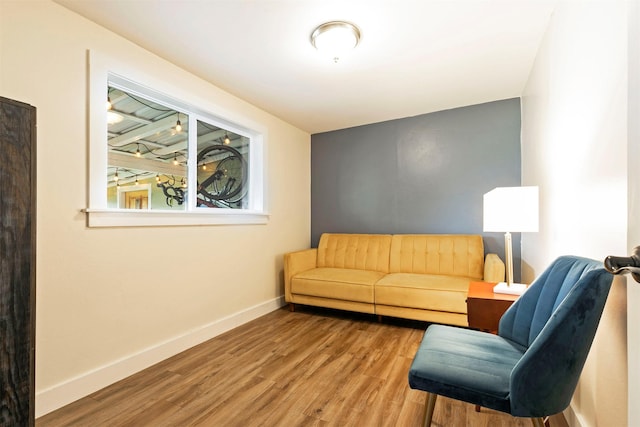living area featuring baseboards and wood finished floors
