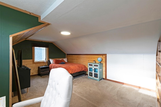 bedroom with carpet floors, vaulted ceiling, wood walls, and a textured ceiling