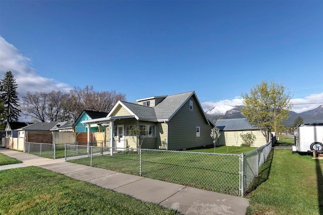 bungalow featuring a shingled roof, fence private yard, and a front lawn