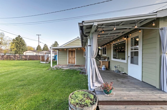 rear view of house featuring a fenced backyard, a lawn, and a deck