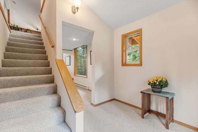 stairway with baseboards, carpet flooring, a baseboard heating unit, and vaulted ceiling