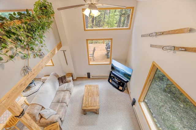 carpeted living room featuring a ceiling fan, baseboards, and a towering ceiling