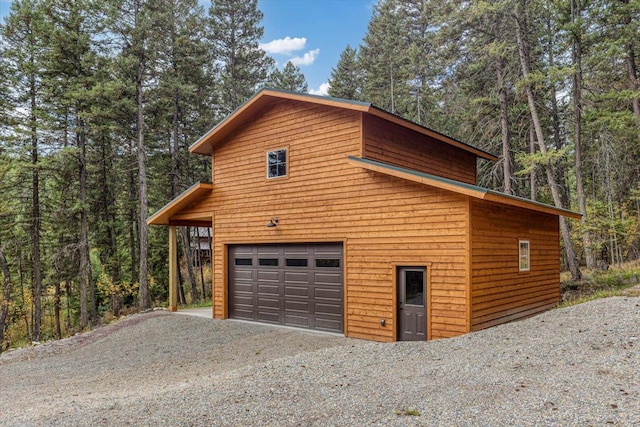 286 Antler Ridge Rd, Whitefish, MT 59937 - garage with a wooded view, a garage, and driveway
