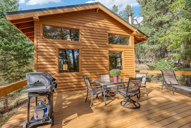 wooden deck with outdoor dining area and area for grilling