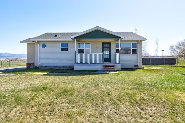 bungalow featuring a porch, fence, and a front lawn