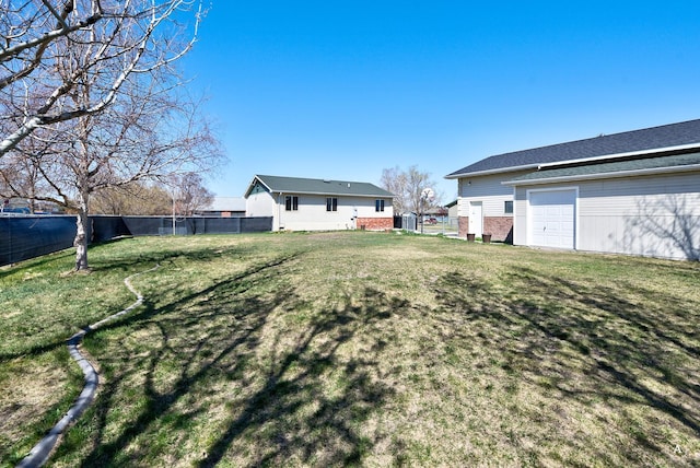 view of yard with fence and a garage