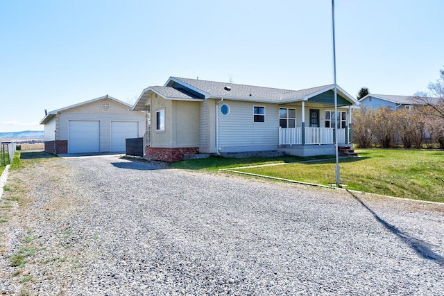ranch-style home with roof with shingles, a garage, a porch, a front yard, and an outbuilding