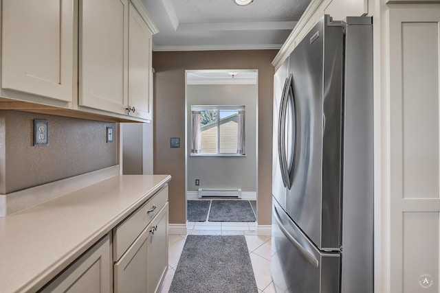 laundry room with crown molding, a baseboard radiator, baseboards, and light tile patterned floors