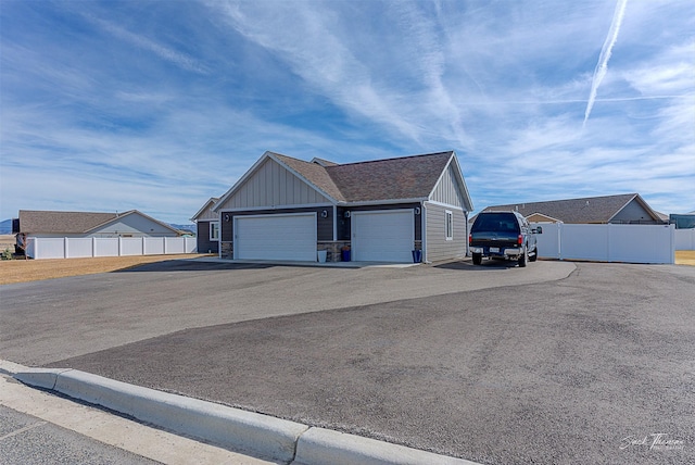 3875 Saint Marys Rd, East Helena, MT 59635 - view of home's exterior featuring board and batten siding, a garage, asphalt driveway, and roof with shingles