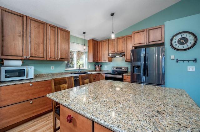 103 Tamarack Woods Dr, Lakeside, MT 59922 - kitchen featuring a sink, stainless steel appliances, brown cabinets, and under cabinet range hood