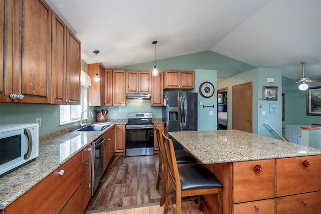 103 Tamarack Woods Dr, Lakeside, MT 59922 - kitchen with brown cabinets, appliances with stainless steel finishes, a sink, dark wood finished floors, and vaulted ceiling