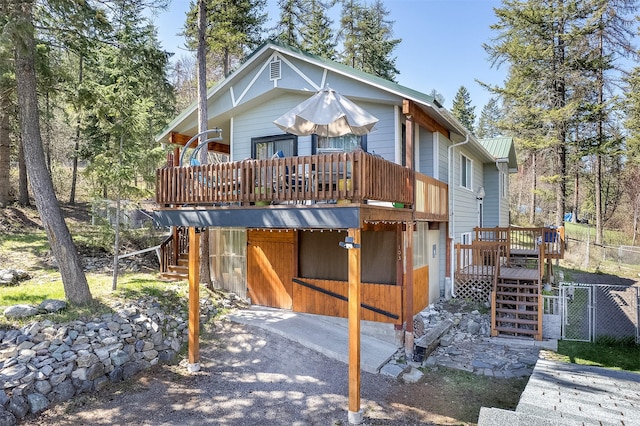 103 Tamarack Woods Dr, Lakeside, MT 59922 - rear view of house featuring stairway, fence, and a wooden deck