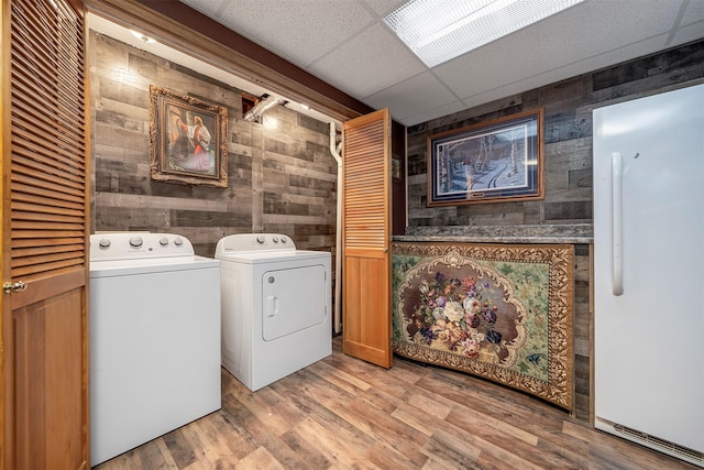 103 Tamarack Woods Dr, Lakeside, MT 59922 - clothes washing area featuring independent washer and dryer, laundry area, wood walls, and light wood-style flooring