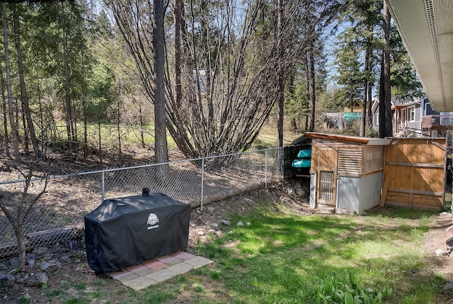 103 Tamarack Woods Dr, Lakeside, MT 59922 - view of yard with a storage unit, a fenced backyard, and an outbuilding