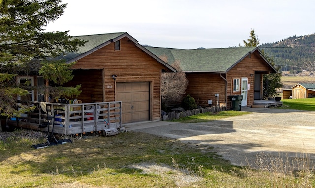 1662 US Highway 2 W, Kalispell, MT 59901 - chalet / cabin with a shingled roof and driveway