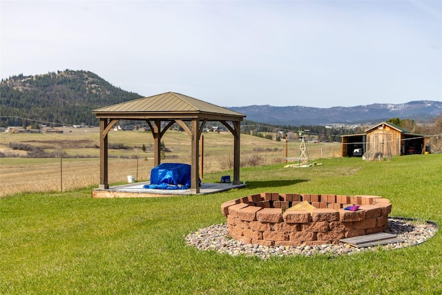 view of yard with a gazebo, a fire pit, a mountain view, and an outbuilding