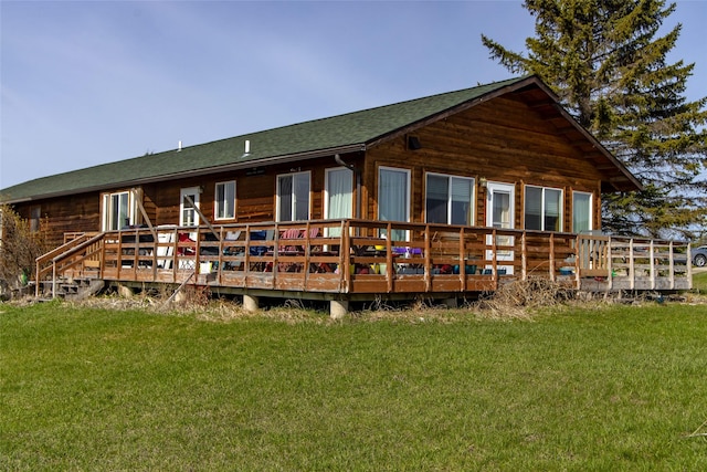 back of house with a lawn, a wooden deck, and a shingled roof