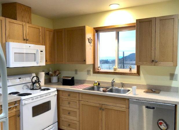 kitchen with a sink, white appliances, and light countertops