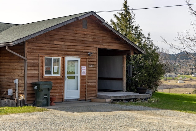 view of front facade with a shingled roof and a mountain view
