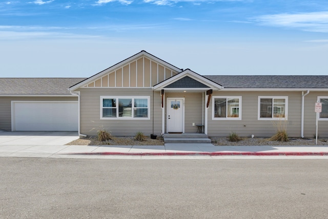 single story home featuring a garage, board and batten siding, a shingled roof, and concrete driveway