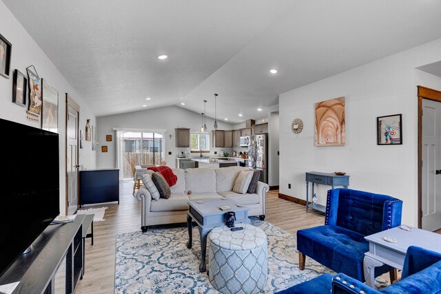 living room featuring recessed lighting, baseboards, light wood finished floors, and lofted ceiling