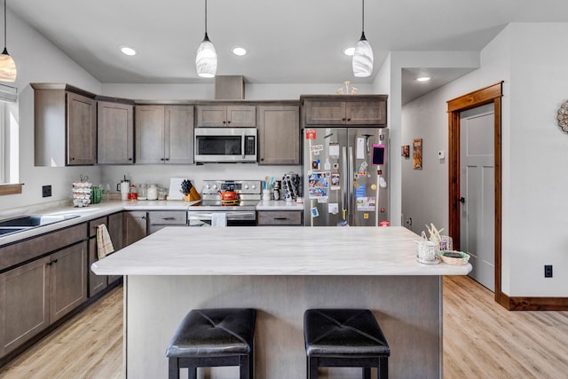 kitchen featuring light wood finished floors, a breakfast bar area, and stainless steel appliances