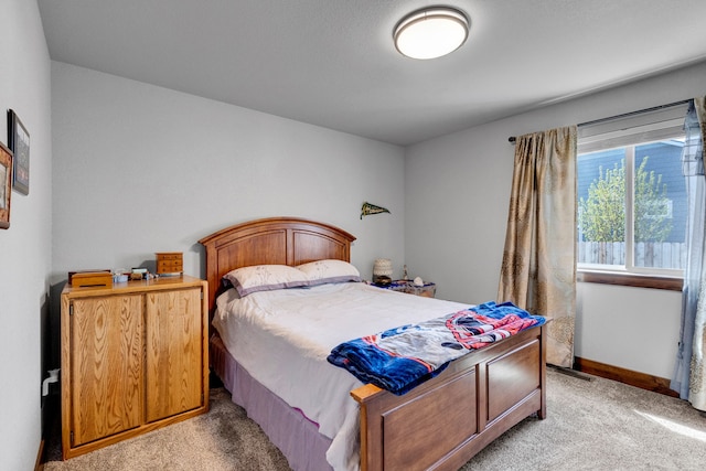 bedroom with light colored carpet and baseboards