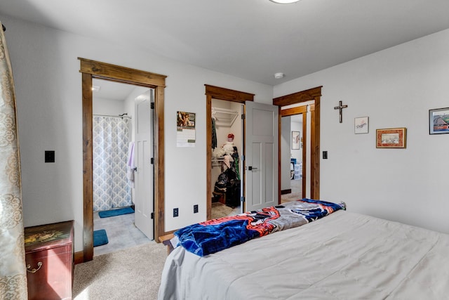 carpeted bedroom featuring ensuite bathroom, a closet, and a spacious closet