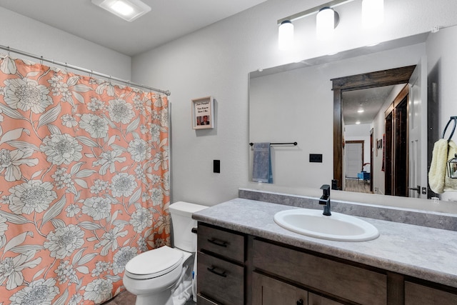 bathroom with vanity, curtained shower, and toilet