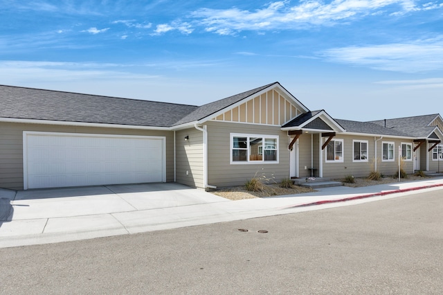 ranch-style home with a garage, board and batten siding, roof with shingles, and driveway