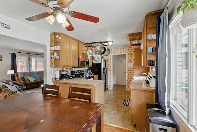kitchen featuring ceiling fan, open shelves, light countertops, a sink, and stainless steel appliances