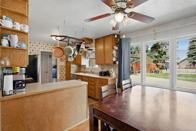 kitchen with light countertops, open shelves, decorative backsplash, and a wealth of natural light