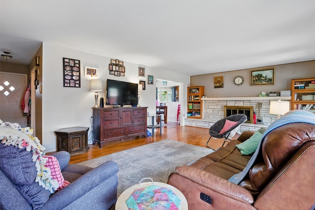 living room featuring baseboards, wood finished floors, and a fireplace