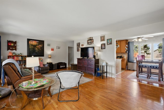 living room with ceiling fan and light wood-type flooring