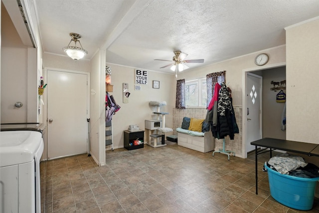 foyer featuring washer and dryer, a textured ceiling, ceiling fan, and stone finish floor