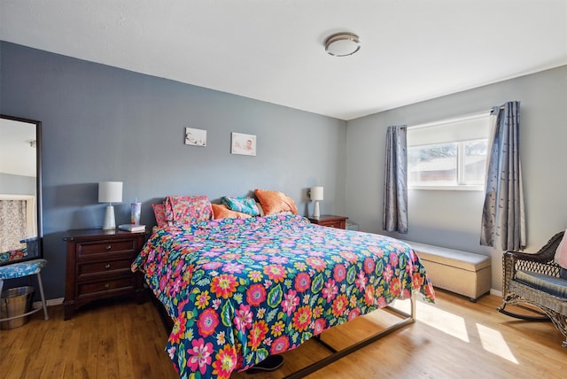 bedroom with baseboards and wood finished floors
