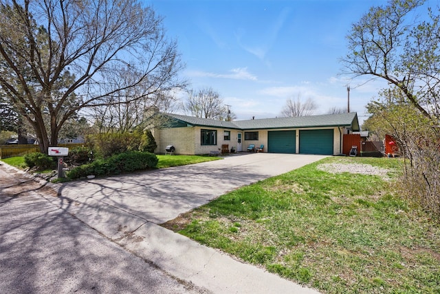 ranch-style home with a front yard, a chimney, brick siding, an attached garage, and driveway