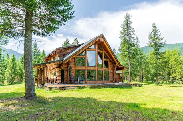 rear view of property with a lawn, log exterior, and a mountain view