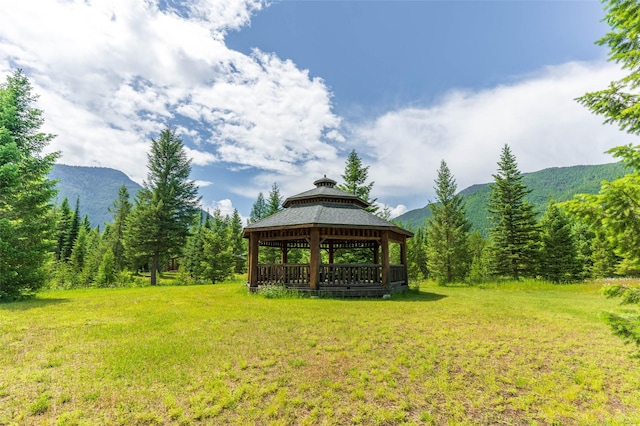view of yard featuring a view of trees, a mountain view, and a gazebo